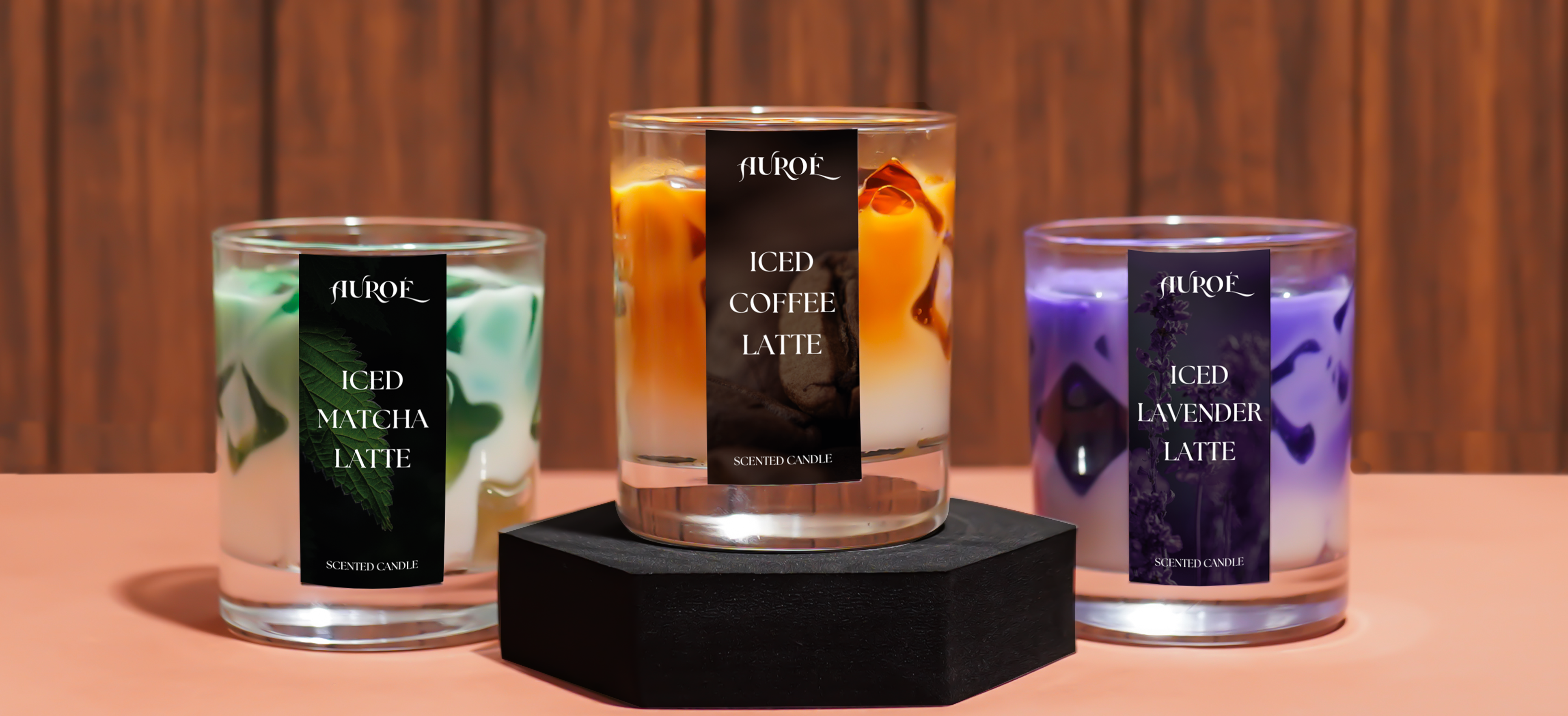 Three 'Auroe' iced coffee latte candles on a wooden surface.