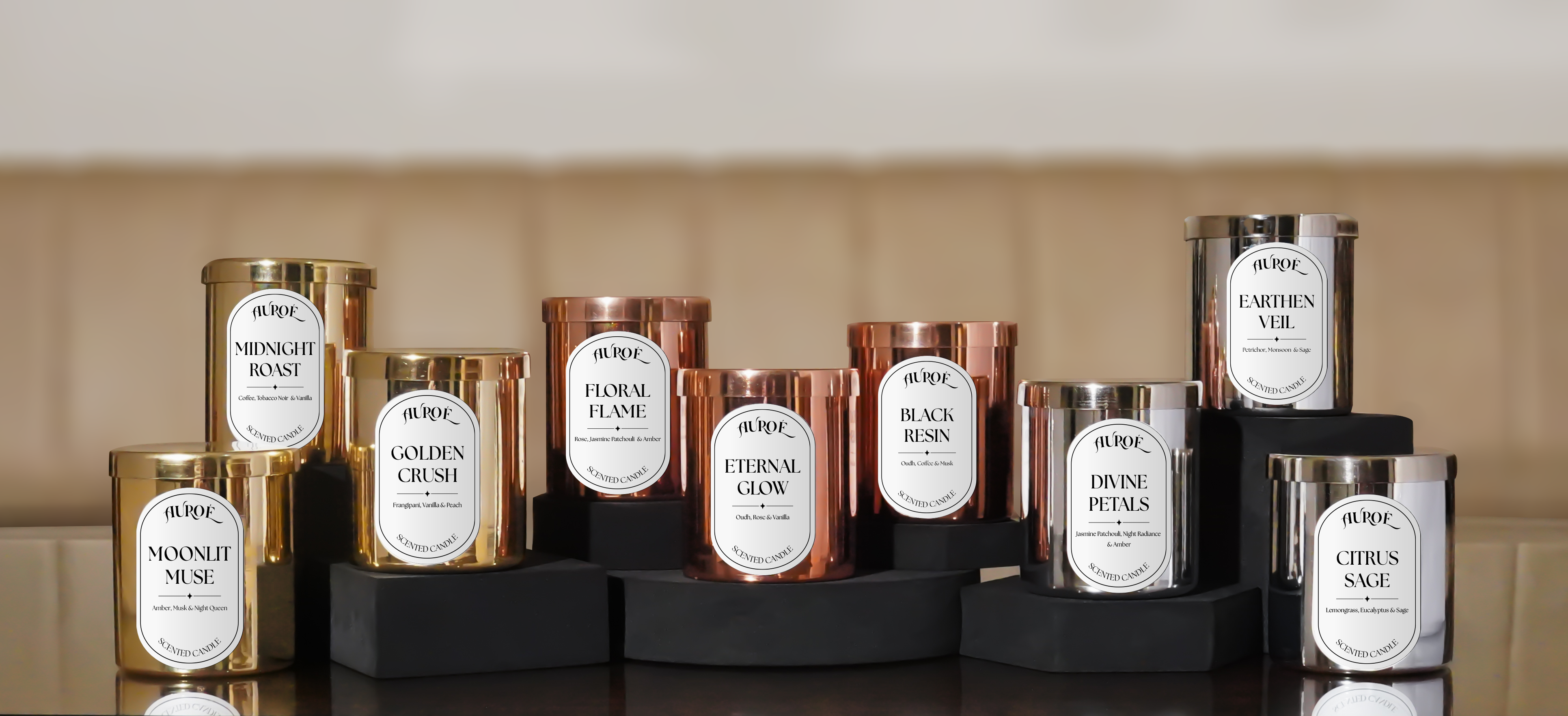 Collection of luxury candles with labels on a reflective surface